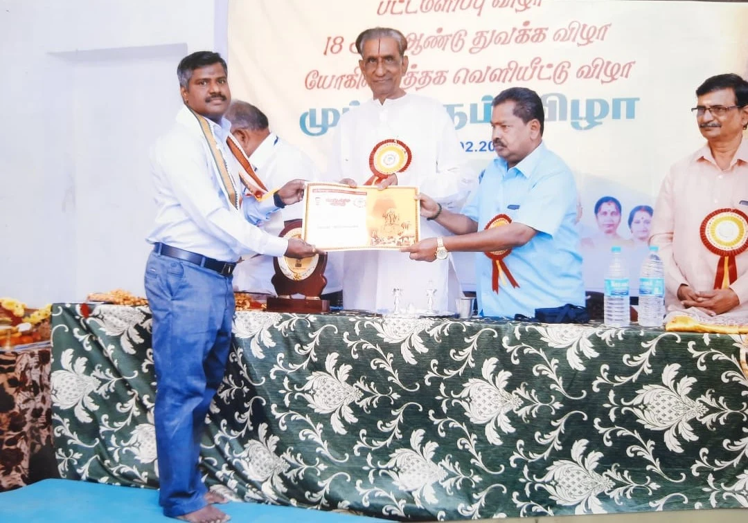 Astro Dr. Chandrasekar receiving an astrology certificate at a Tamil community event